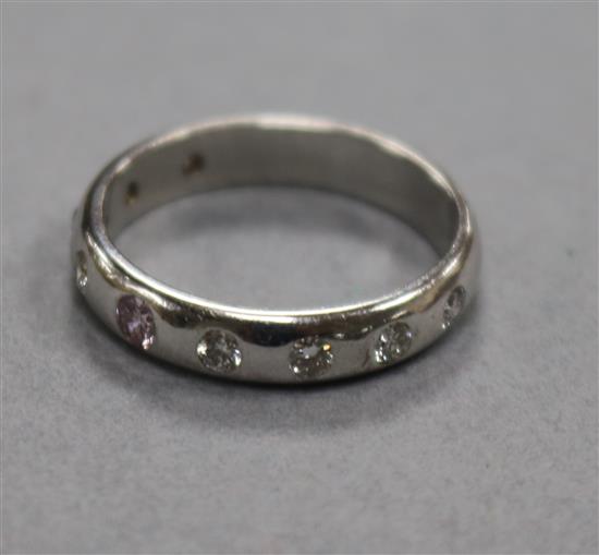 A modern 18ct white gold and gypsy set nine stone diamond ring, size N.